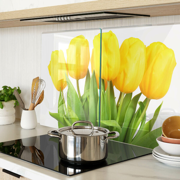 Üveg vágódeszka fényképpel Sárga tulipánok zöld háttér előtt
