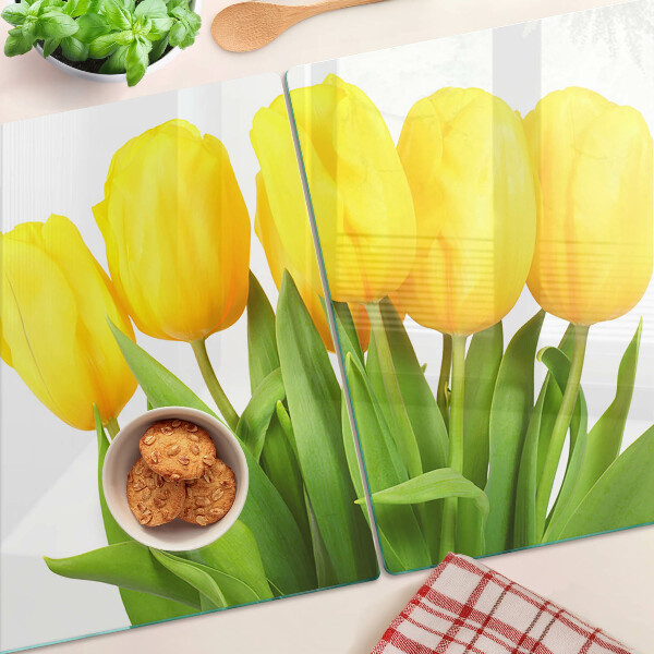 Üveg vágódeszka fényképpel Sárga tulipánok zöld háttér előtt