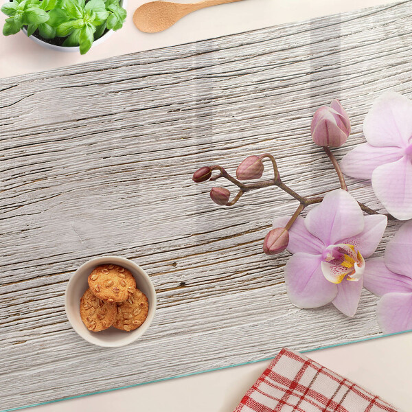 Üveg vágódeszka fényképpel Orchideák fa háttéren