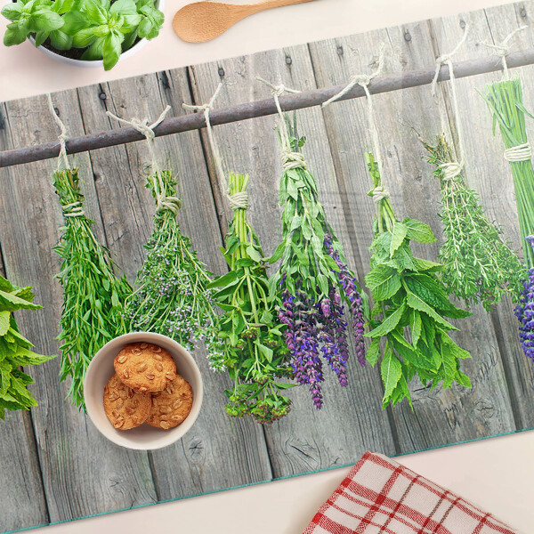 Üveg vágódeszka fényképpel Szárított gyógynövények fa háttéren