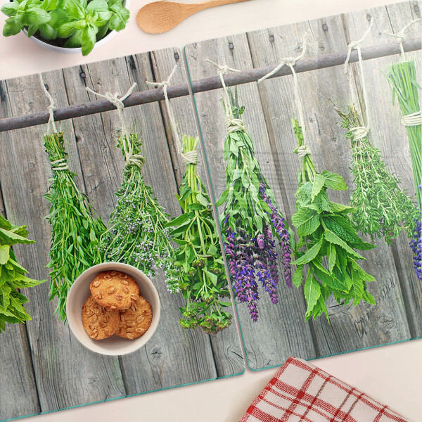 Üveg vágódeszka fényképpel Szárított gyógynövények fa háttéren