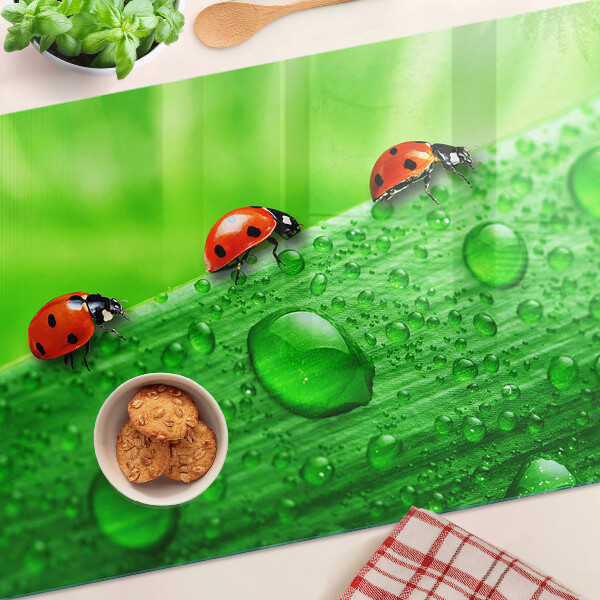 Üveg vágódeszka fényképpel Katicabogarak zöld háttéren