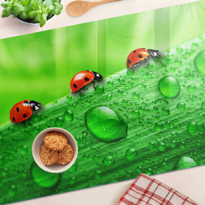 Üveg vágódeszka fényképpel Katicabogarak zöld háttéren