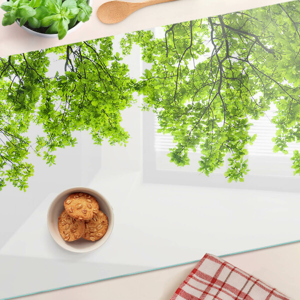 Üveg vágódeszka fényképpel Zöld levelek az ég ellen