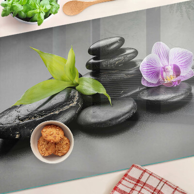 Üveg vágódeszka Kövek és orchidea a háttérben
