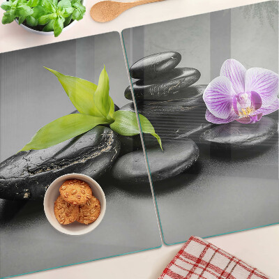 Üveg vágódeszka Kövek és orchidea a háttérben
