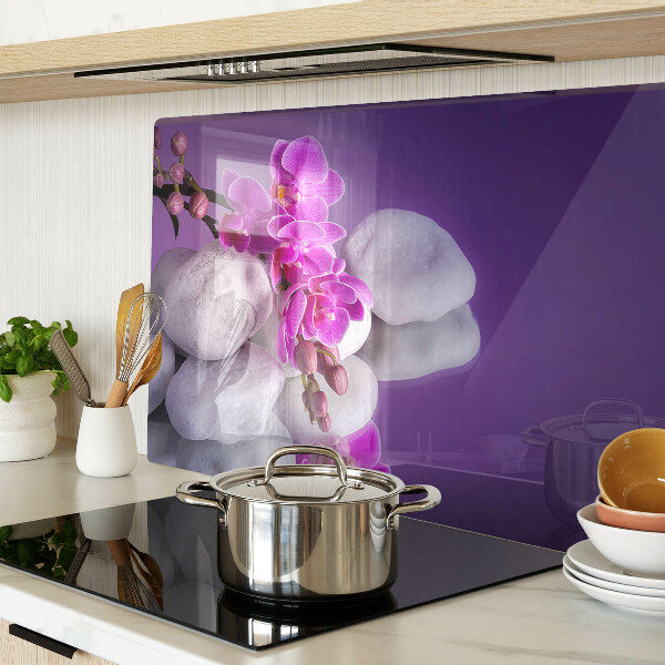 Üveg vágódeszka fényképpel Orchidea virágok kövek hátterében