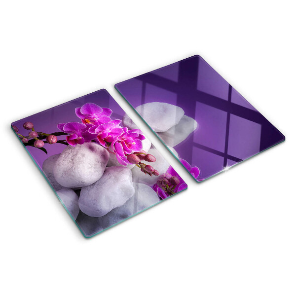 Üveg vágódeszka fényképpel Orchidea virágok kövek hátterében