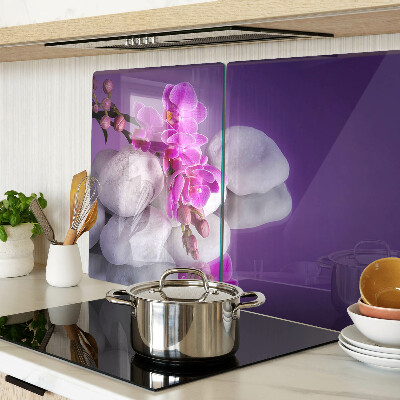 Üveg vágódeszka fényképpel Orchidea virágok kövek hátterében