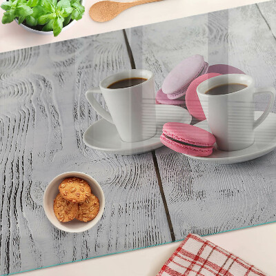 Üveg vágódeszka fényképpel Kávé és macarons egy fából készült háttéren