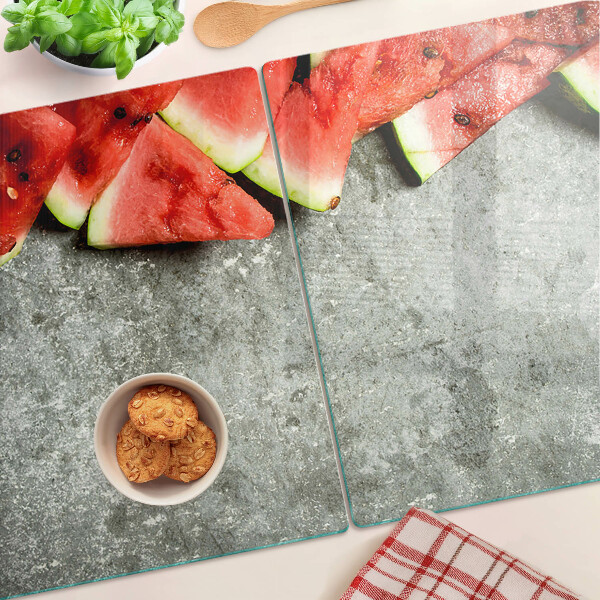 Üveg vágódeszka fényképpel Görögdinnye szeletek szürke háttéren