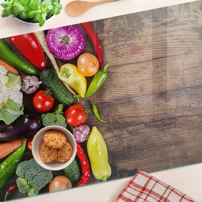 Edzett üveg vágódeszka Zöldségek fa háttéren