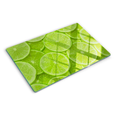 Üveg vágódeszka fényképpel Lime szeletek zöld háttéren