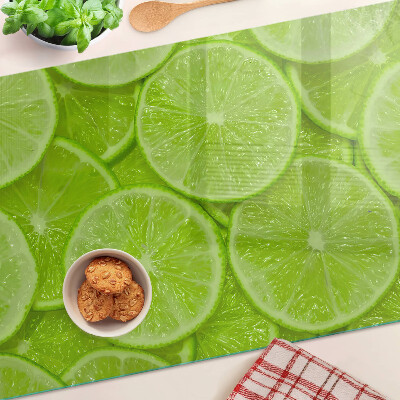 Üveg vágódeszka fényképpel Lime szeletek zöld háttéren