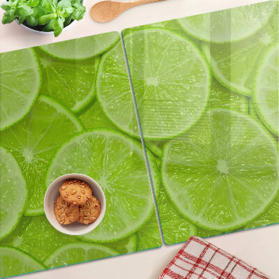 Üveg vágódeszka fényképpel Lime szeletek zöld háttéren