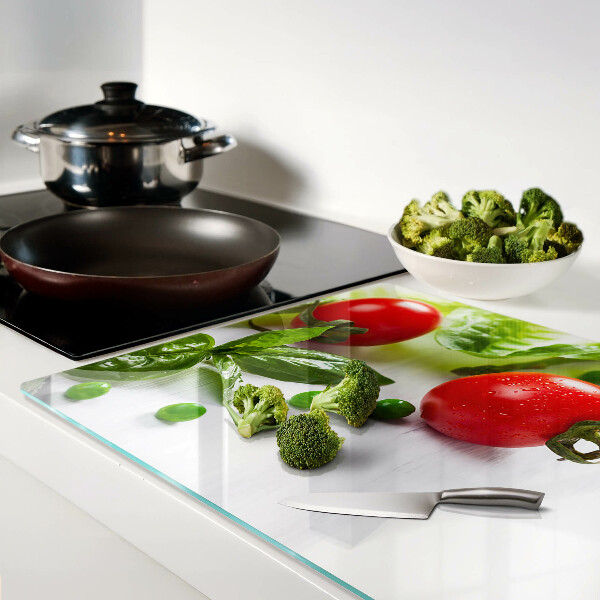 Üveg vágódeszka fényképpel Zöldségek egy fehér konyhapulton