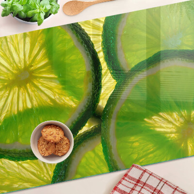 Üveg vágódeszka fényképpel Lime szeletek zöld háttéren