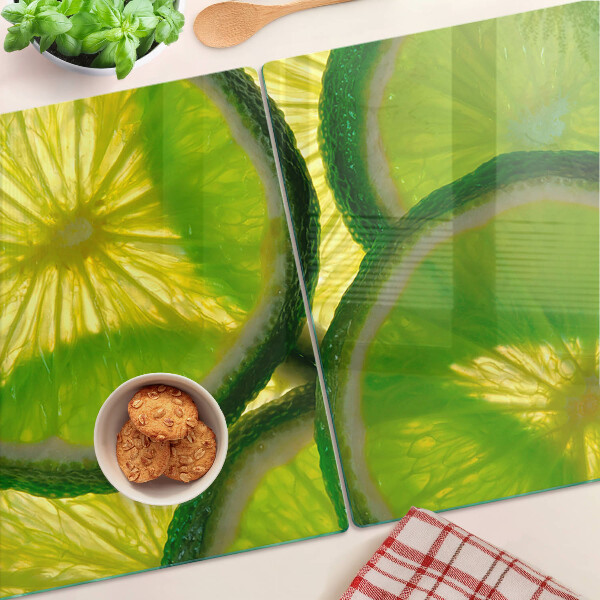 Üveg vágódeszka fényképpel Lime szeletek zöld háttéren
